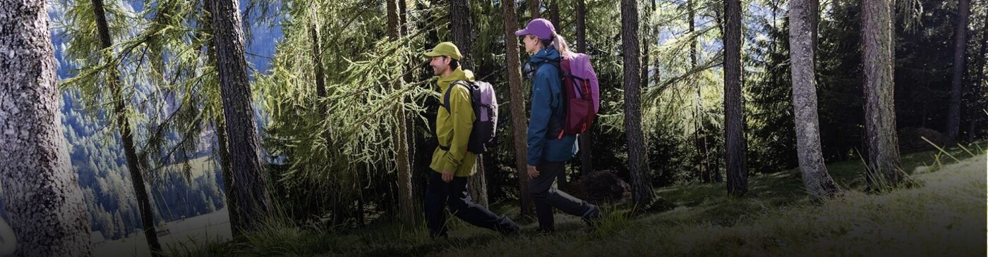 Eine Frau und ein Mann im Wald beim Wandern.