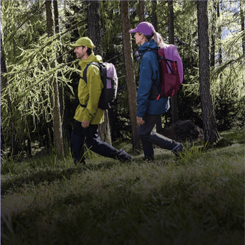 Eine Frau und ein Mann im Wald beim Wandern.